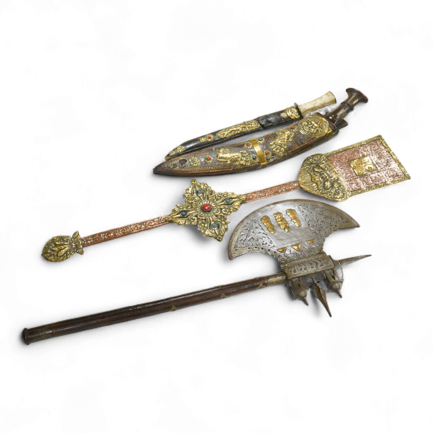 A decorative Indian axe, the large head inlaid with brass Hindu figures, together with a brass mounted North Indian kukri, another similar knife with bone handle, and a large shovel-shaped copper and brass item possibly